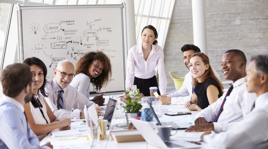 Asian Businesswoman Leading Meeting At Boardroom Table